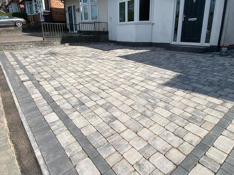 Light grey Tegula-style block driveway with dark double border