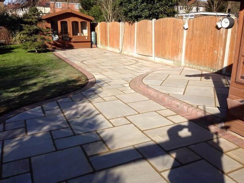 Garden patio with curved brick detailing and summerhouse
