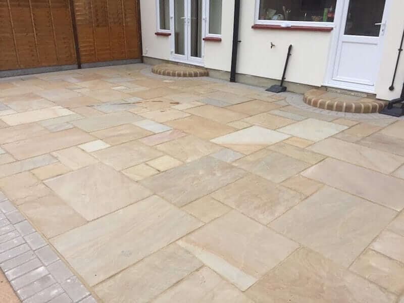Pale garden paving with a curved step outside patio doors