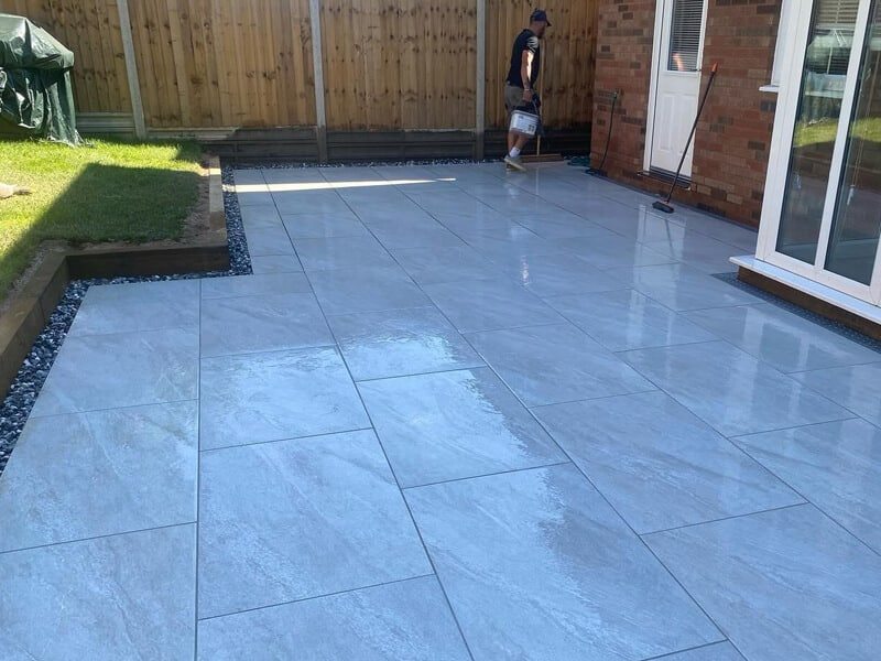 Large grey porcelain slabs forming a garden patio