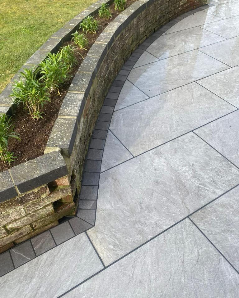 Porcelain paving detail meeting a curved raised garden bed