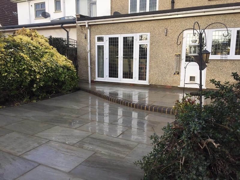 Kandla Grey sandstone patio beside a garden and French doors