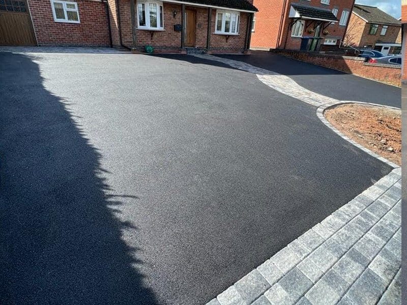 Smooth black tarmac driveway with a curved block border