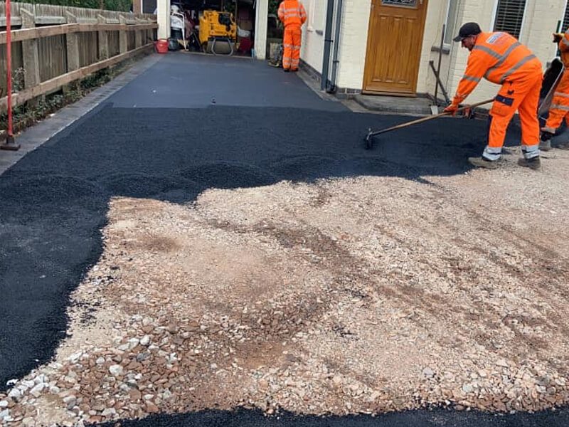 Tarmac being spread and levelled during driveway installation